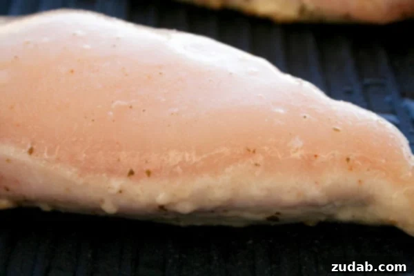 Pan-Seared Chicken Breasts: Juicy Perfection 2 Perfectly pan-seared chicken breast with a golden brown, crispy crust, resting on a cutting board, ready to be sliced and served.