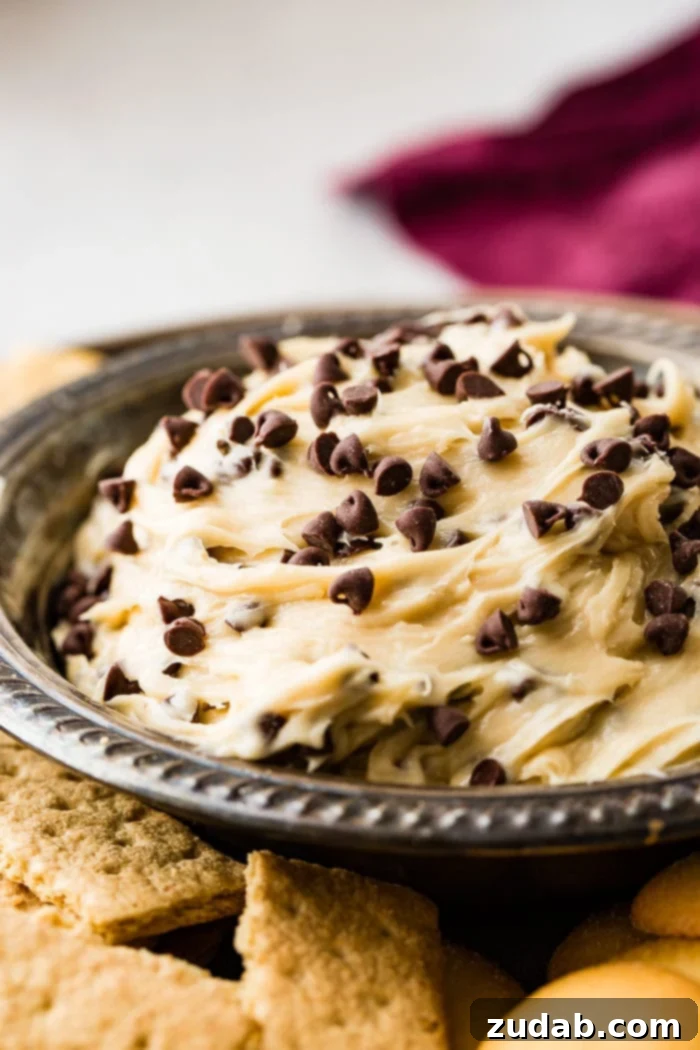No-Bake Chocolate Chip Cookie Dough Dip 4 Another view of a metal bowl filled with creamy chocolate chip cookie dough dip, showcasing its inviting texture and rich color.