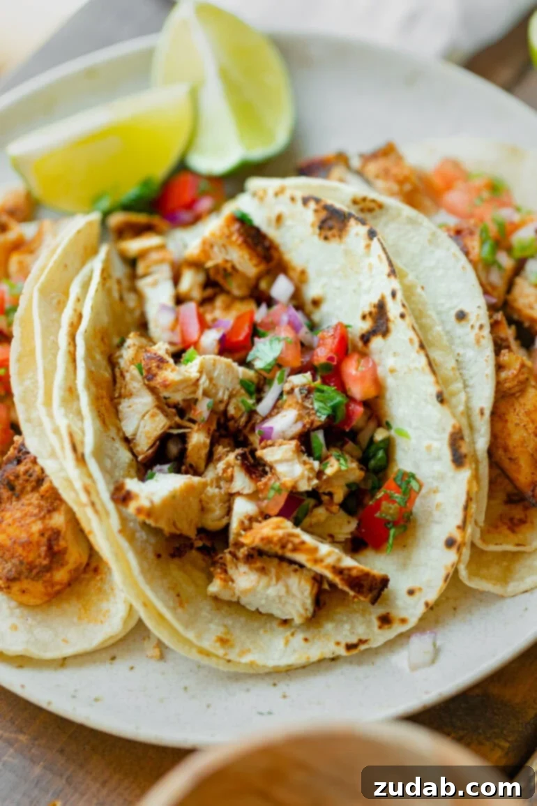 Quick and Delicious 30-Minute Grilled Chicken Tacos 3 A close-up photo of a single grilled chicken taco, generously filled with chopped grilled chicken and topped with fresh, colorful pico de gallo, ready to be picked up and enjoyed.