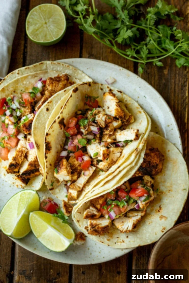 Quick and Delicious 30-Minute Grilled Chicken Tacos 5 A vibrant photo showcasing several grilled chicken tacos nestled in soft corn tortillas, generously adorned with fresh pico de gallo and ready to be served, perfect for a family meal or entertaining.