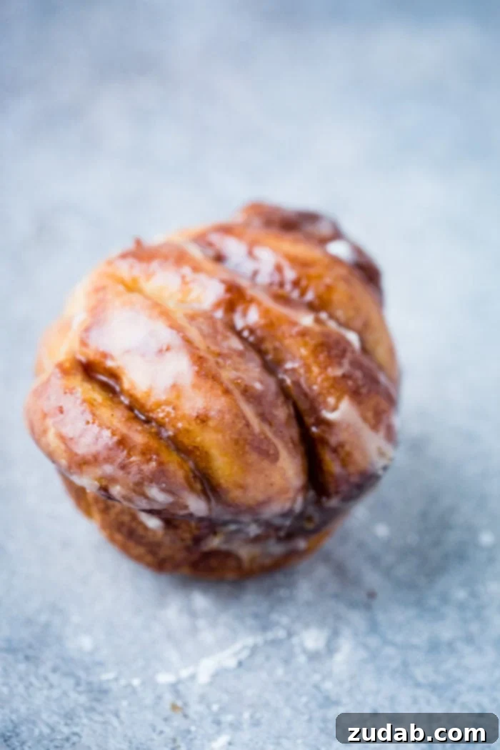 Irresistible Maple Glazed Cinnamon Butterflake Rolls 3 A single butterflake roll with a light maple glaze
