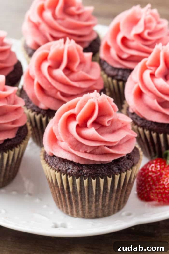 An array of beautifully frosted chocolate cupcakes with strawberry buttercream, showcasing different angles and the tempting combination of flavors.