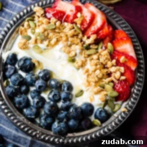 Instant pot homemade yogurt in a vintage bowl with a drizzle of honey and granola with pepitas and fresh blueberries and sliced strawberries for a healthy breakfast recipe