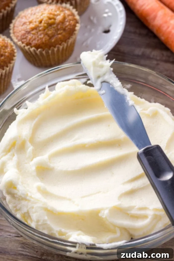 Homemade Cream Cheese Frosting in a Bowl A pristine white bowl filled with creamy, fluffy cream cheese frosting, ready to be piped onto cupcakes