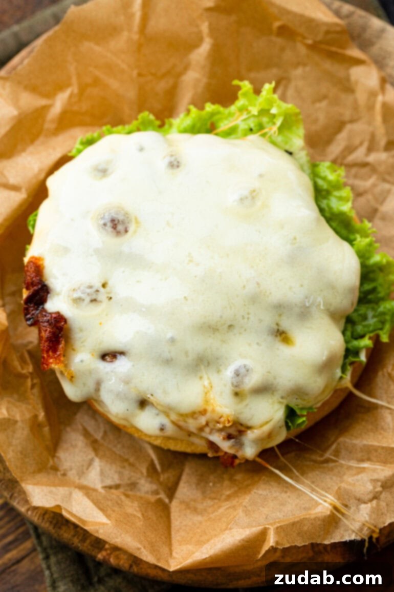 Tropical Heat Turkey Burgers 3 A close-up shot of a grilled turkey burger patty, perfectly topped with melted Havarti cheese, ready for its bun and delicious pineapple jalapeño sauce.
