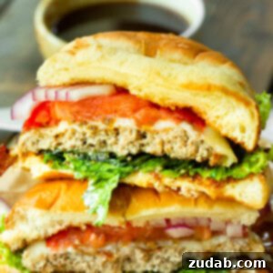 A perfectly cooked pineapple jalapeño turkey burger, sliced in half to reveal its juicy interior, melted Havarti cheese, and a rich, sweet-spicy sauce, on a brioche bun.