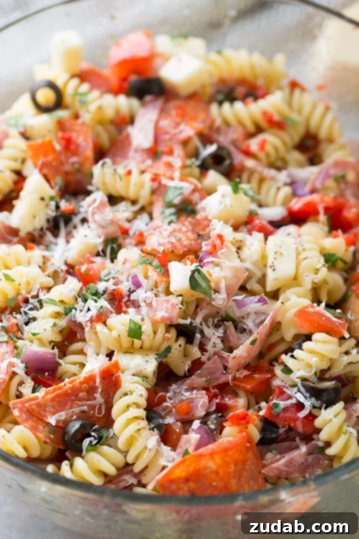 Effortless Italian Pasta Salad 5 A glass bowl of quick and easy Italian pasta salad recipe with homemade Italian dressing. Rotini pasta with pepperoni, salsami, black olives, parmesan cheese, mozzarella cheese, peppers, dressing and red onions!