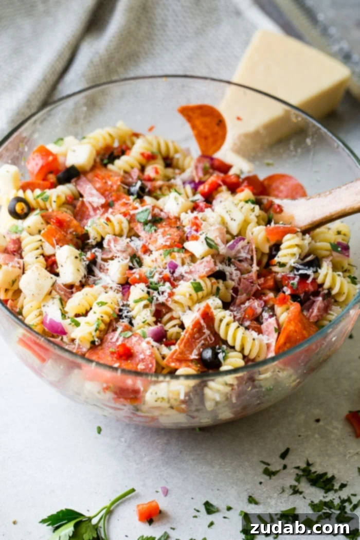 Effortless Italian Pasta Salad 6 A glass bowl of quick and easy Italian pasta salad recipe with homemade Italian dressing. Rotini pasta with pepperoni, salsami, black olives, parmesan cheese, mozzarella cheese, peppers, dressing and red onions!