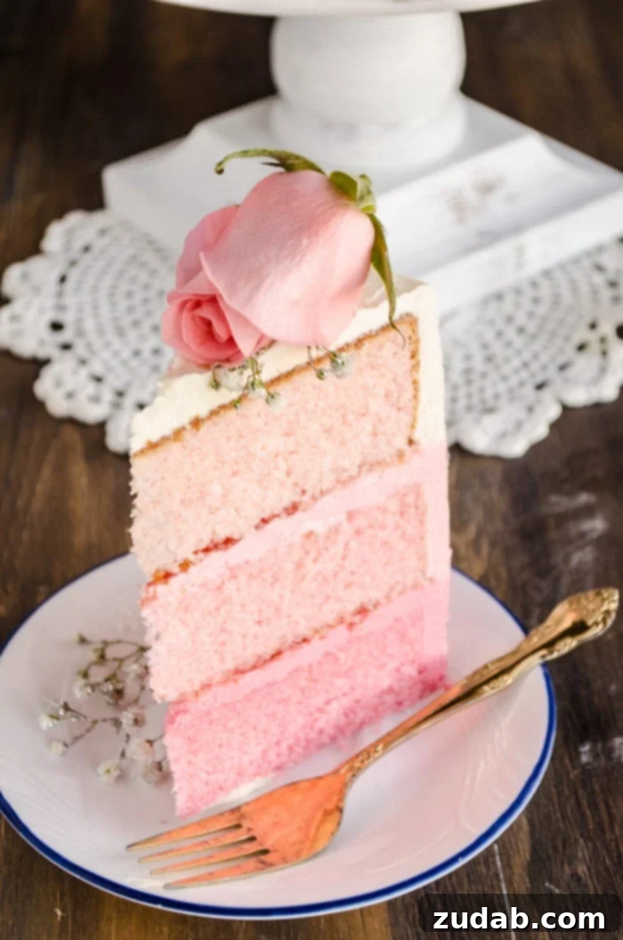 Blushing Strawberry Ombre Cake 3 A close-up view of a slice of the ombre cake, revealing its beautiful gradient of three distinct pink layers, perfectly presented on a plate alongside a fork, inviting you to indulge in its deliciousness.