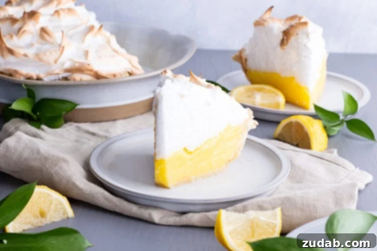 Mom's Secret Lemon Meringue Pie 2 A beautifully composed photograph of a single slice of lemon meringue pie, resting elegantly on a small white dessert plate.