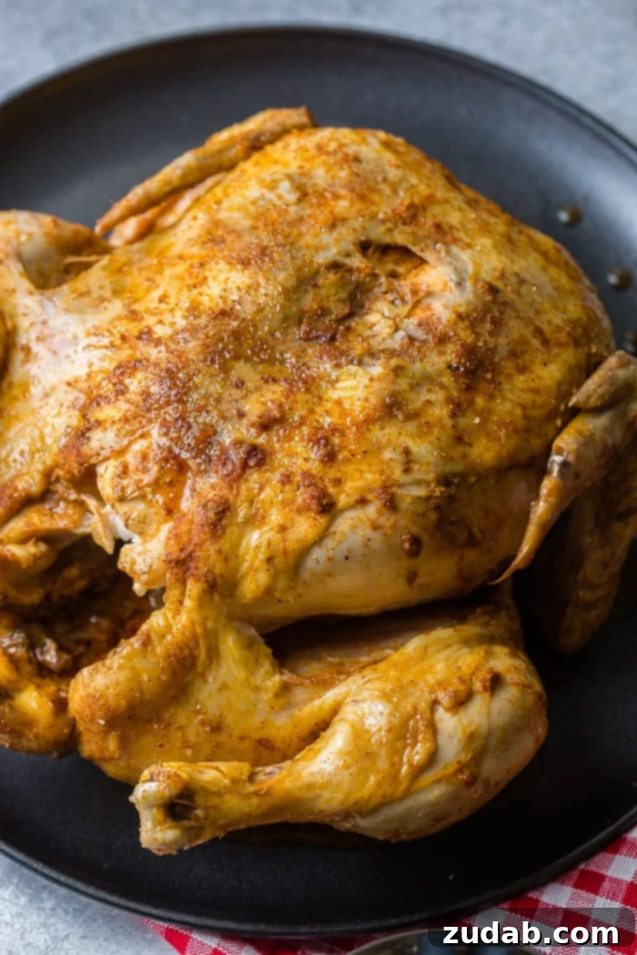 A red and white checkered napkin under a grey plate with a bbq instant pot whole chicken on top! 