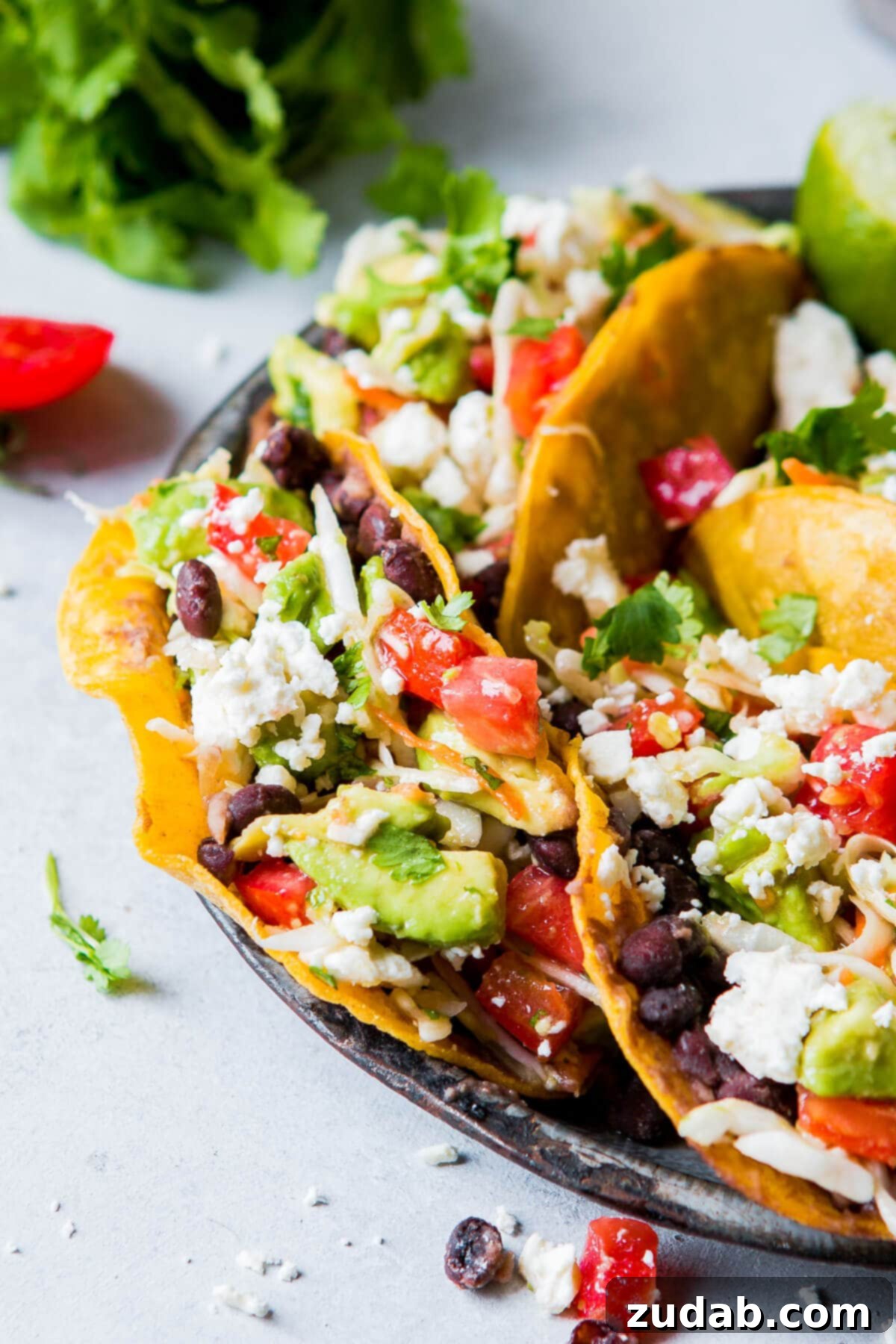 black bean vegetarian tacos topped with slaw on gray plate