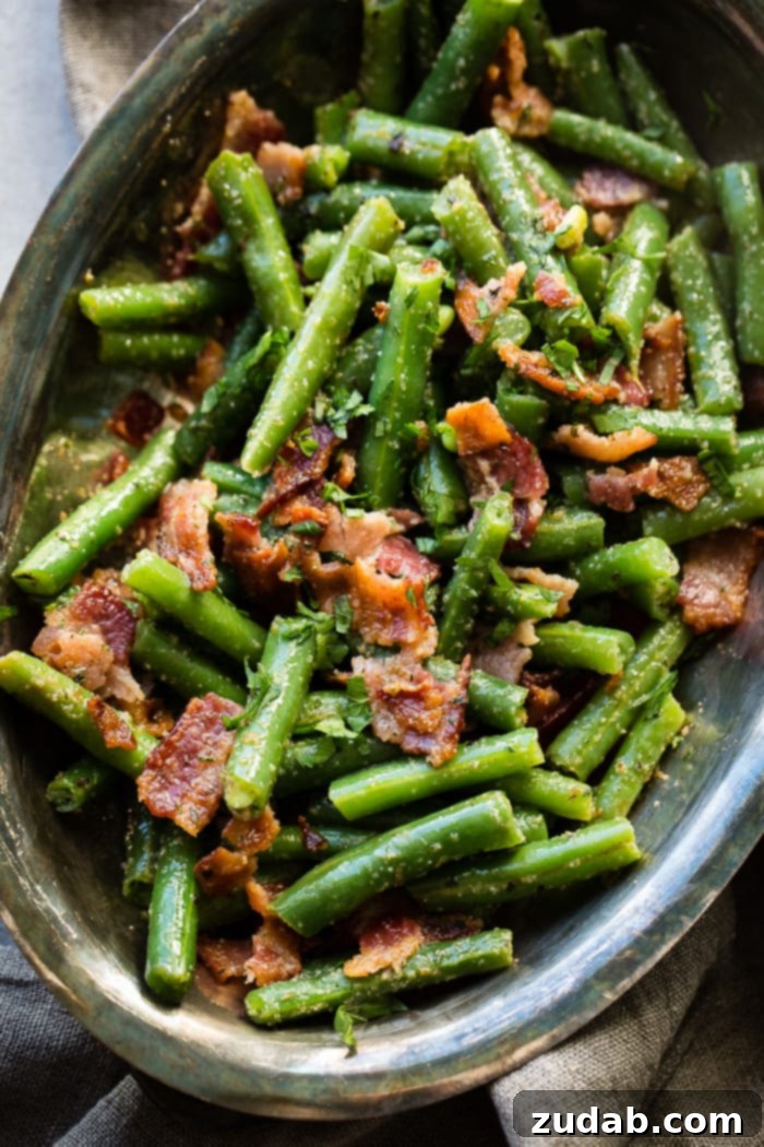 Quick Bacon Green Beans 5 Chopped green beans, beautifully arranged in a vintage silver serving bowl, generously topped with crumbled bacon and fresh parsley bits.