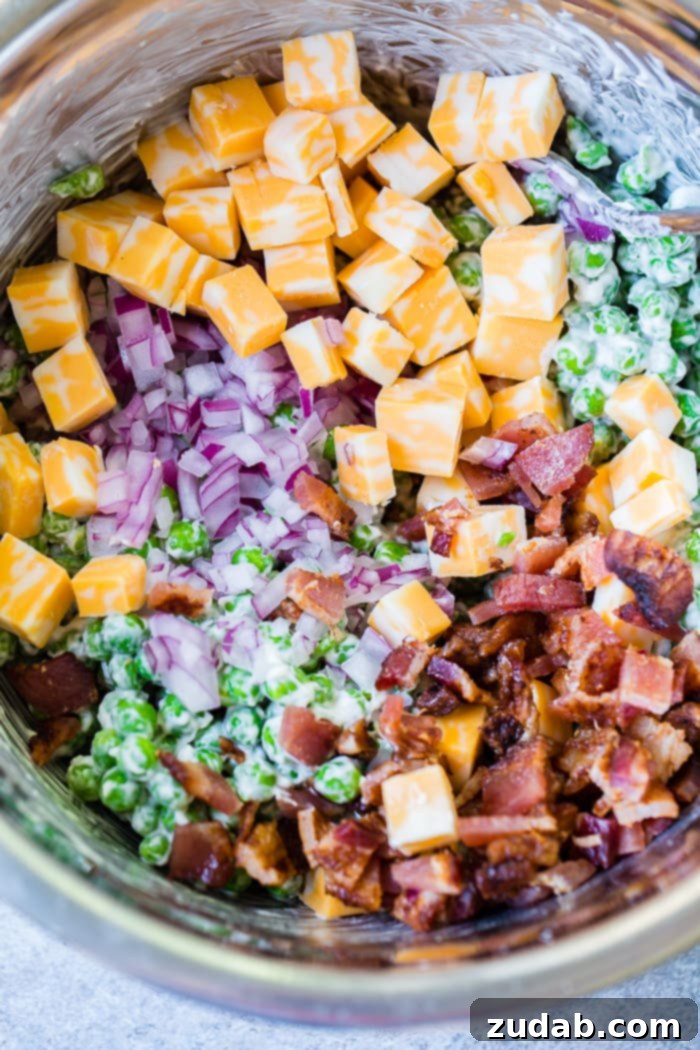 Creamy Southern Pea Salad 3 a metal bowl full of creamy southern english pea salad with bacon, chunks of colby jack cheese