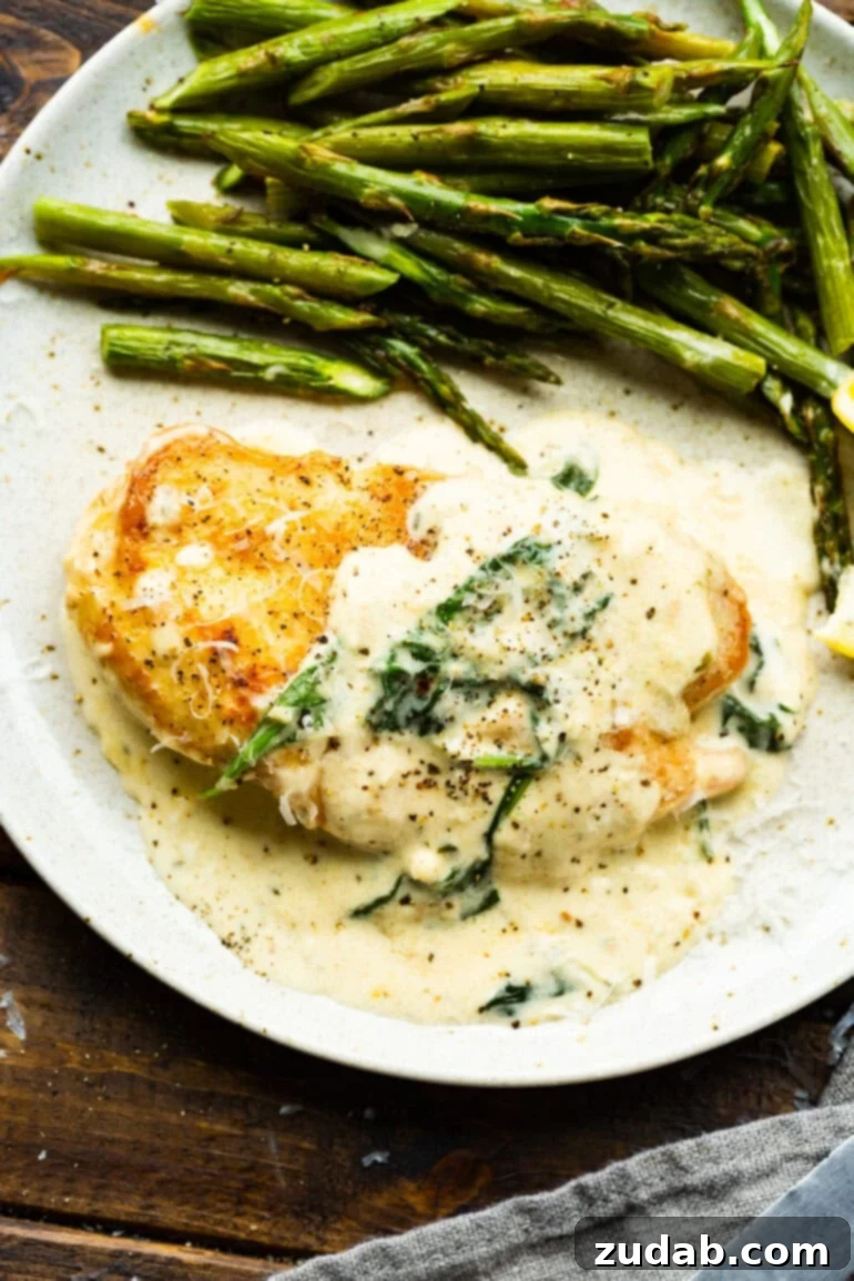 Chicken Florentine 2 A golden breaded chicken breast covered in a creamy sauce with spinach and a side of asparagus