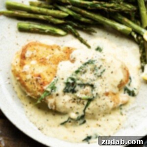 Chicken Florentine on a white plate with asparagus