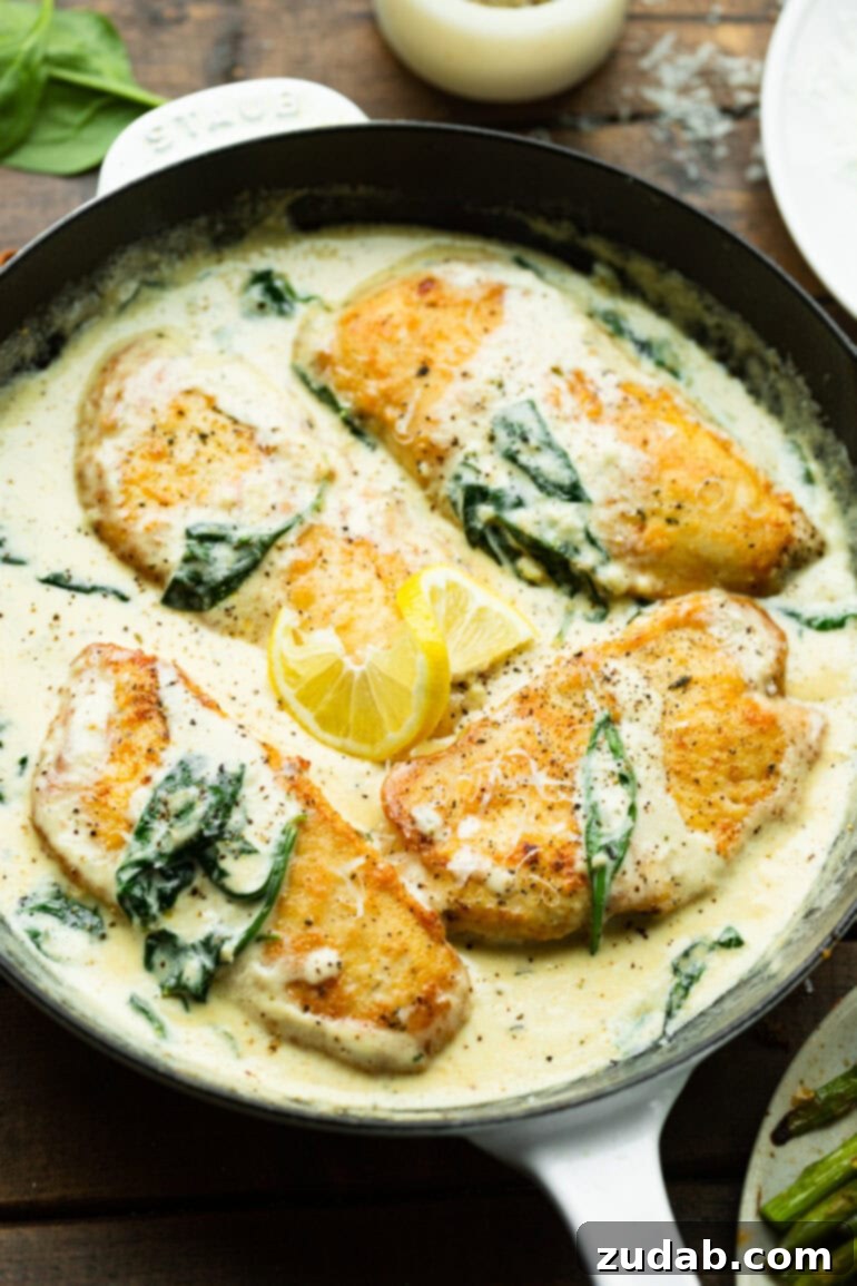 Chicken Florentine 9 A large cast-iron skillet filled with creamy spinach sauce, four golden lightly breaded chicken breasts, and a slice of lemon