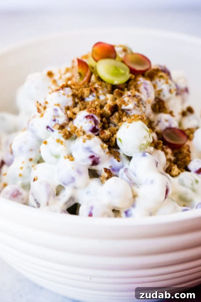 Creamy Southern Grape and Pecan Medley 2 A beautifully presented white bowl brimming with Southern Grape Salad, topped generously with crunchy pecans, ready to be served at a family gathering or potluck.