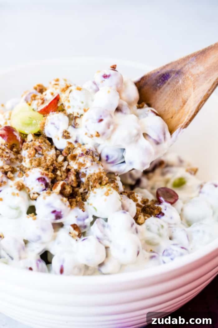 Creamy Southern Grape and Pecan Medley 4 A large white serving bowl showcasing the delightful Southern Grape Salad with Pecans, featuring a mix of whole and halved grapes, and a golden-brown candied pecan topping.