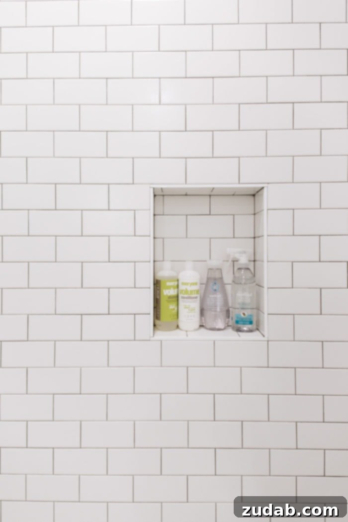 Basement Bathroom Transformation With The Best Tile of 2018 7 View of the stylish black and white tile bathroom, highlighting the modern glass shower and thoughtful amenities.