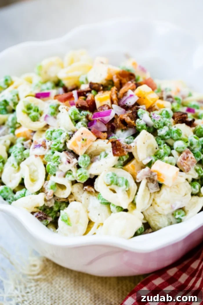 Southern Comfort Pea Pasta Salad 5 A white bowl with orchiette pasta, peas, cubed colby jack cheese, red onion and a simple dressing for the recipe southern pea pasta salad