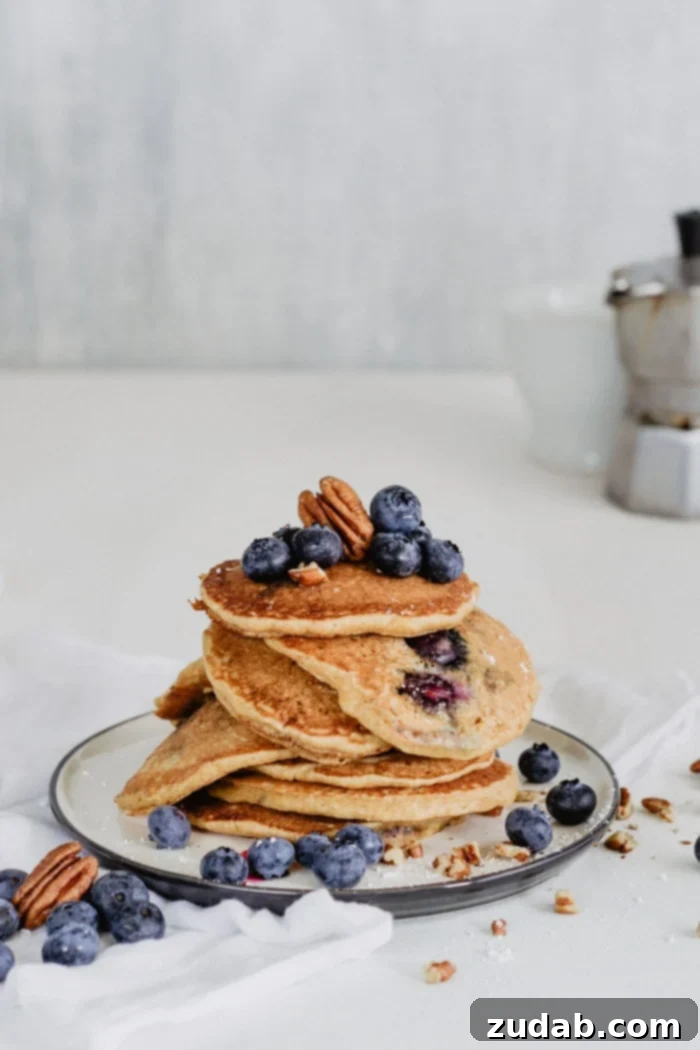 Ultimate Blueberry Pecan Pancakes 4 A beautifully plated stack of blueberry pecan pancakes, garnished with fresh blueberries and pecans, inviting a delightful breakfast experience.