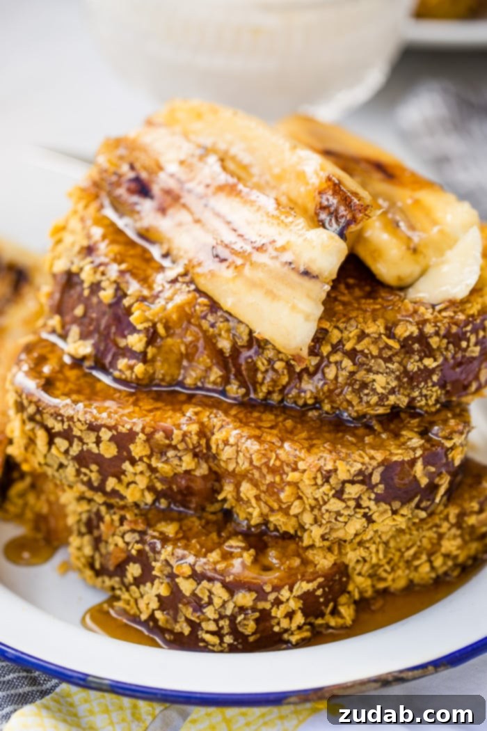 Cade's Signature Bananas Foster French Toast 10 A beautiful drizzle of bananas foster syrup being poured over a stack of cornflake-crusted French toast.
