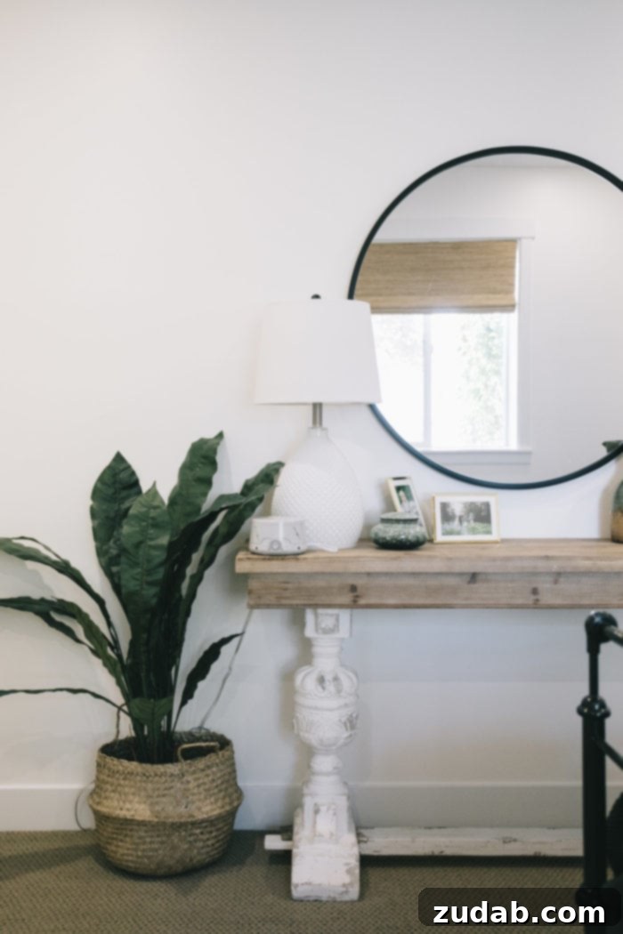 Stunning Basement Bedroom Makeovers 11 A modern guest bedroom featuring an Urban Outfitters Black Round Mirror positioned over a minimalist side table, beside which stands a vibrant floor plant. This view emphasizes the clean lines and contemporary aesthetic of the room, inviting a sense of calm.