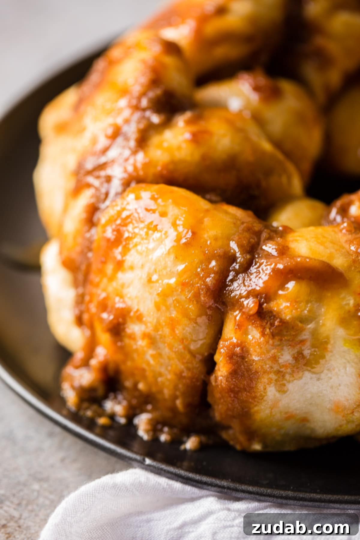 Mom's Legendary Sticky Buns 2 Delicious golden-brown Mom's Sticky Buns fresh from the oven, drizzled with sweet caramel glaze.