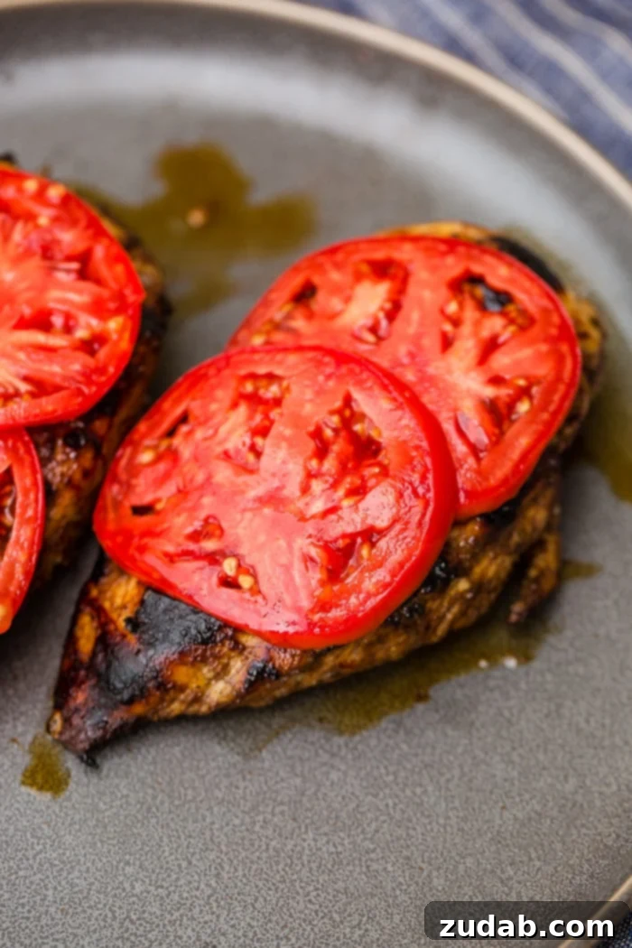 Close-up of baked Balsamic Caprese Chicken, with melted mozzarella and fresh basil garnish