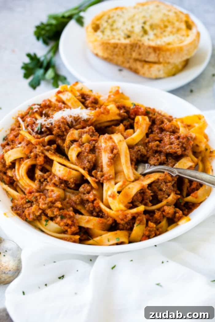 Mastering Authentic Italian Bolognese 6 A close-up of delicious fettuccine pasta with a generous serving of authentic Italian Bolognese sauce.