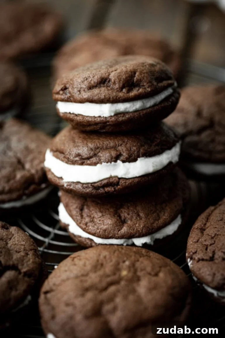 Craft Your Own Delicious Oreos 3 A photo of a stack of three homemade Oreo cookies, with more cookies scattered around on a surface, highlighting their appealing texture and filling.
