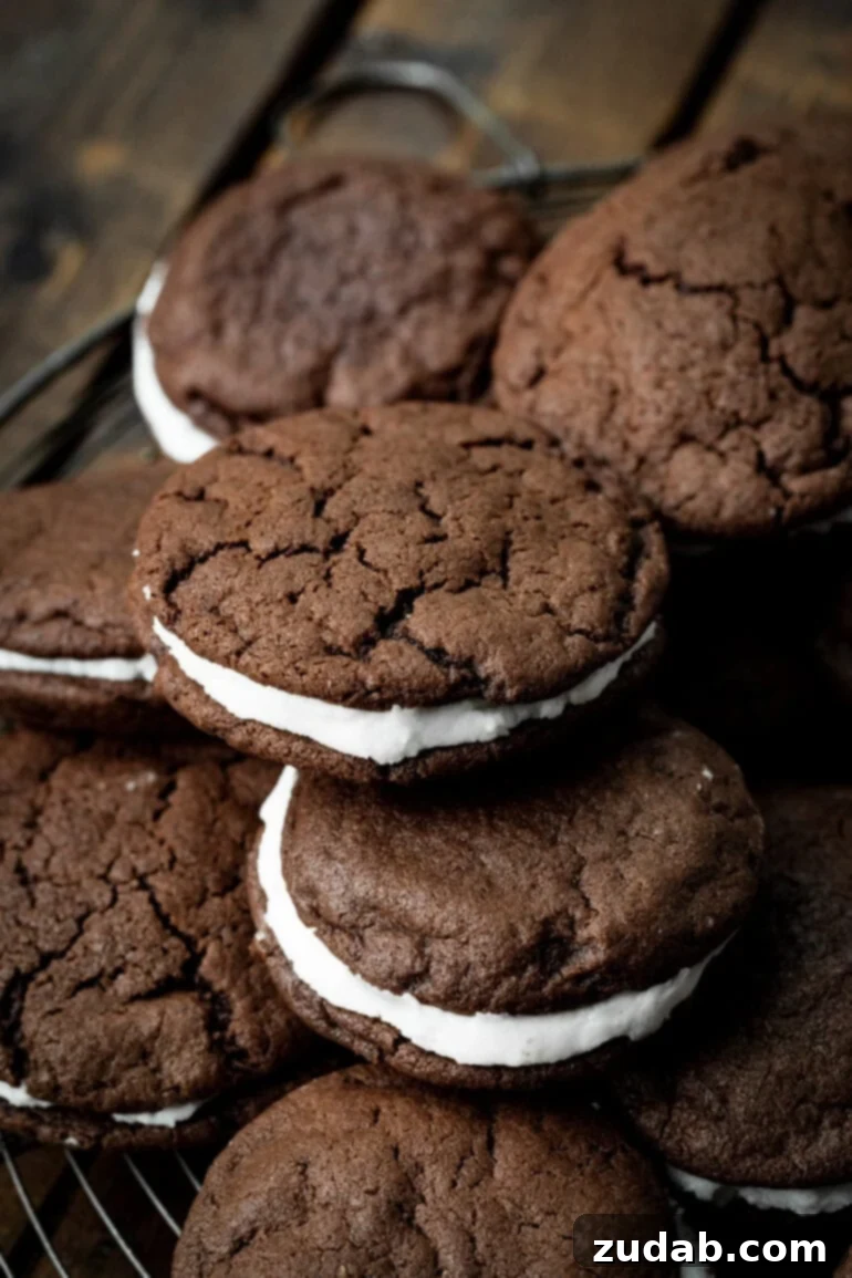 Craft Your Own Delicious Oreos 8 A photo of several homemade Oreo cookies piled on each other, resting on a circular wire cooling rack, showcasing their perfection.