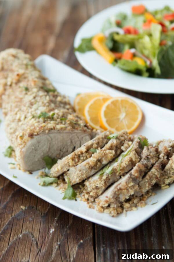 The only moist pork tenderloin, herb and almond crusted pork tenderloin ohsweetbasil.com Sliced moist pork tenderloin with herb and almond crust, ready to serve