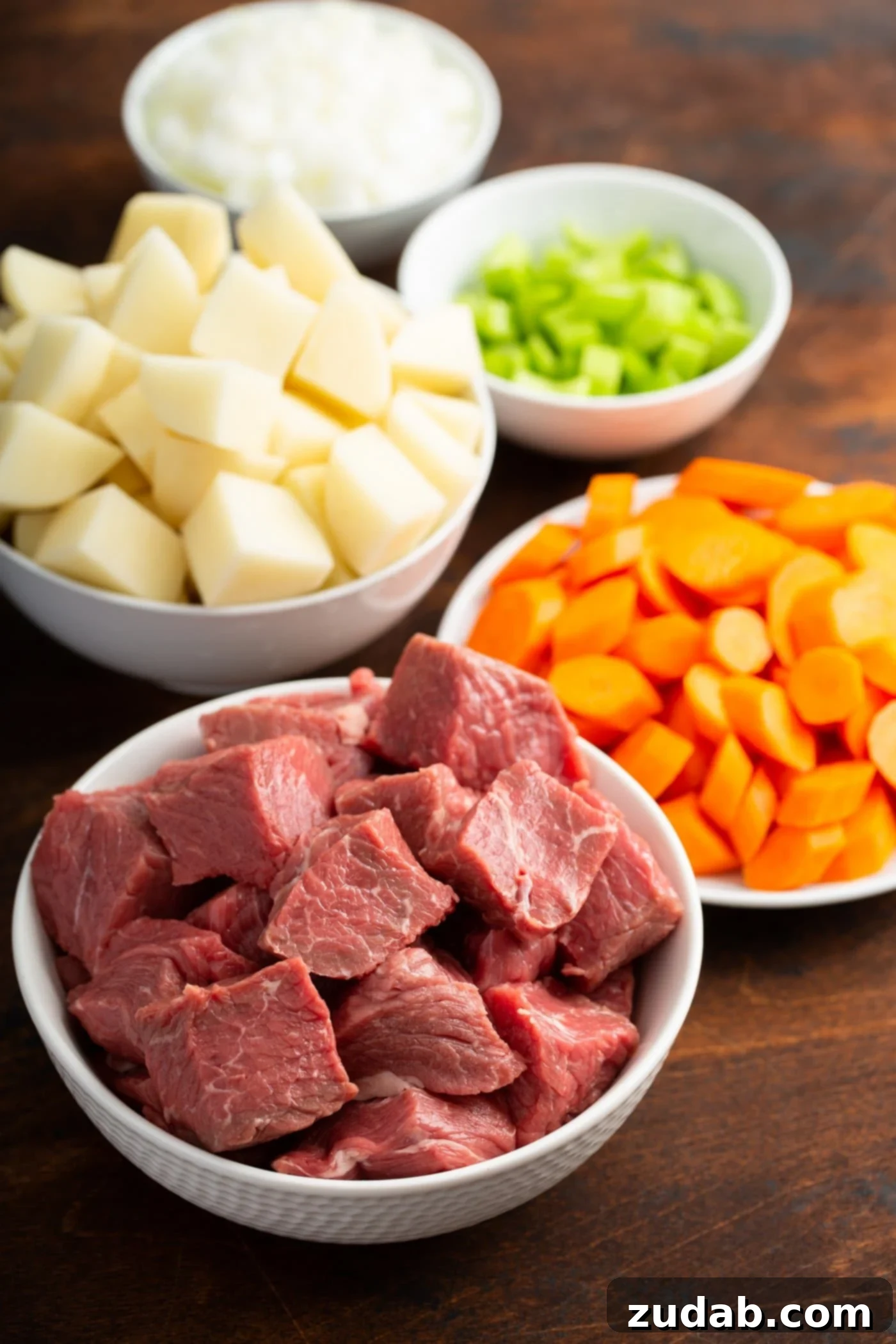 Instant Pot Beef Stew Dishes of cubed beef, cut carrots, cut potatoes, and celery.