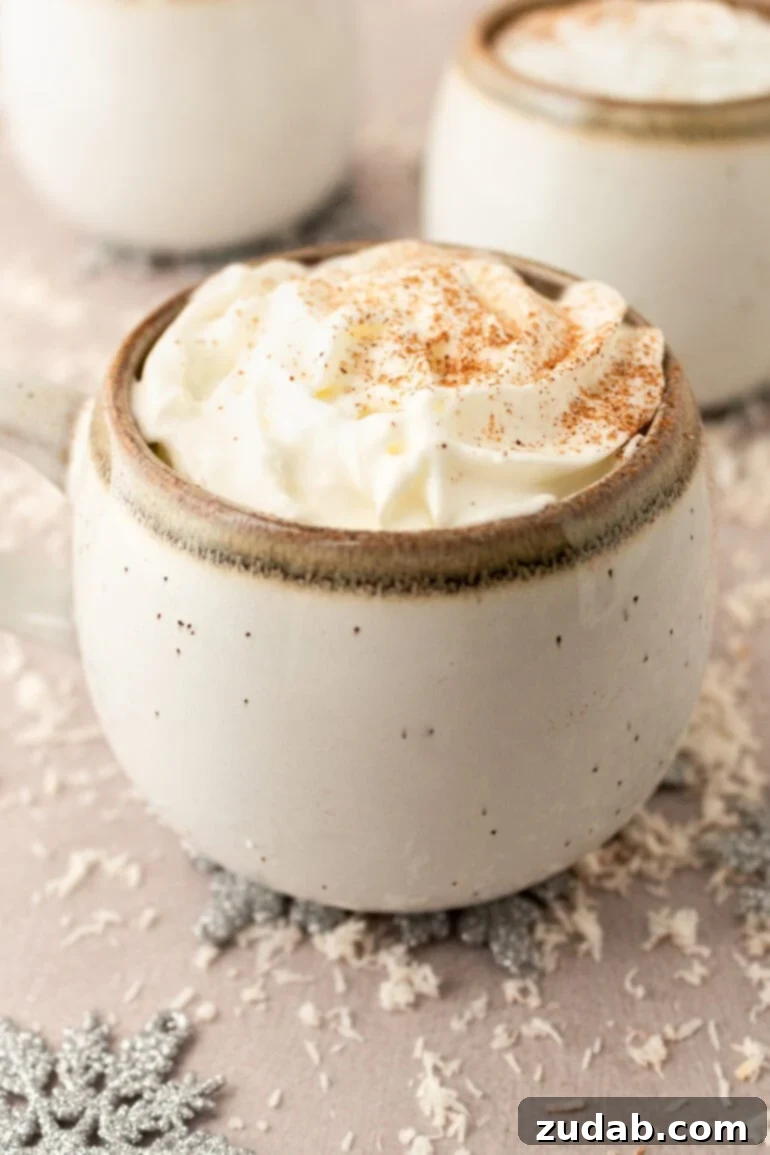 Snowman Milk Creamy White Hot Chocolate 9 A inviting mug of warm vanilla milk, beautifully topped with whipped cream and a sprinkle of cinnamon, nestled beside a plate of delicious cookies for dunking.
