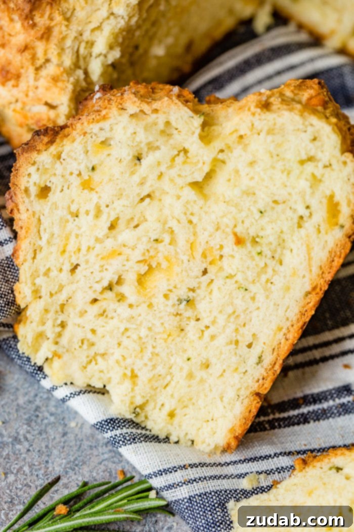 Garlic Cheddar Herb Irish Soda Bread 3 A photo of a slice of garlic cheddar herb irish soda bread sitting on a blue and white striped cloth napkin.