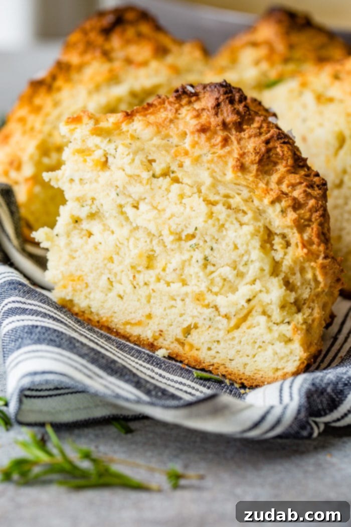 Garlic Cheddar Herb Irish Soda Bread 4 A photo of a slice of garlic cheddar herb irish soda bread sitting on a blue and white striped cloth napkin.