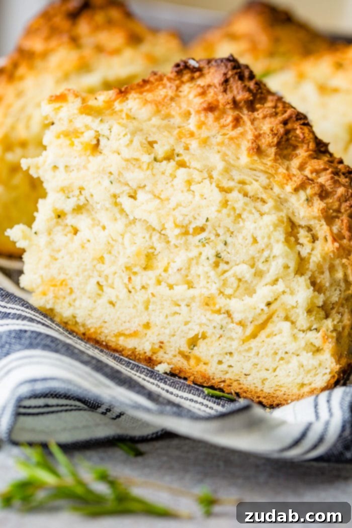 Garlic Cheddar Herb Irish Soda Bread 6 A photo of a slice of garlic cheddar herb irish soda bread sitting on a blue and white striped cloth napkin.