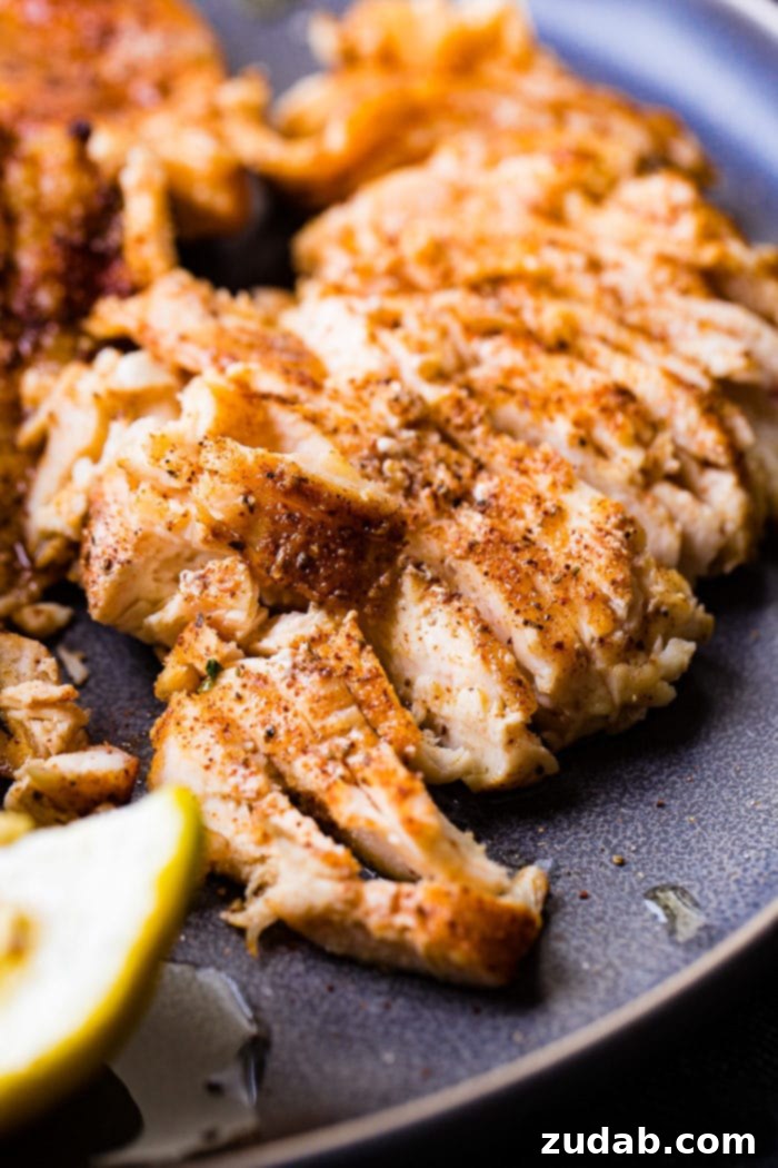 Juicy Traeger Smoked Chicken Breast, Effortlessly 5 A photo of sliced smoked chicken breasts and on a charcoal gray plate.