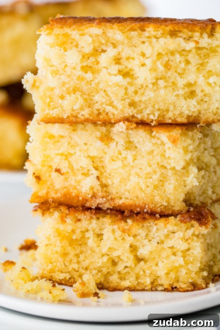 The Ultimate Moist and Sweet Cornbread Recipe with Video 6 A simple yet inviting photo of three pieces of golden-brown homemade cornbread stacked neatly, showcasing their delightful texture.