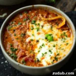 Delicious Lasagna Soup Recipe 12 A top-down view of a hearty bowl of Lasagna Soup, garnished with fresh herbs and a melted cheese pull.