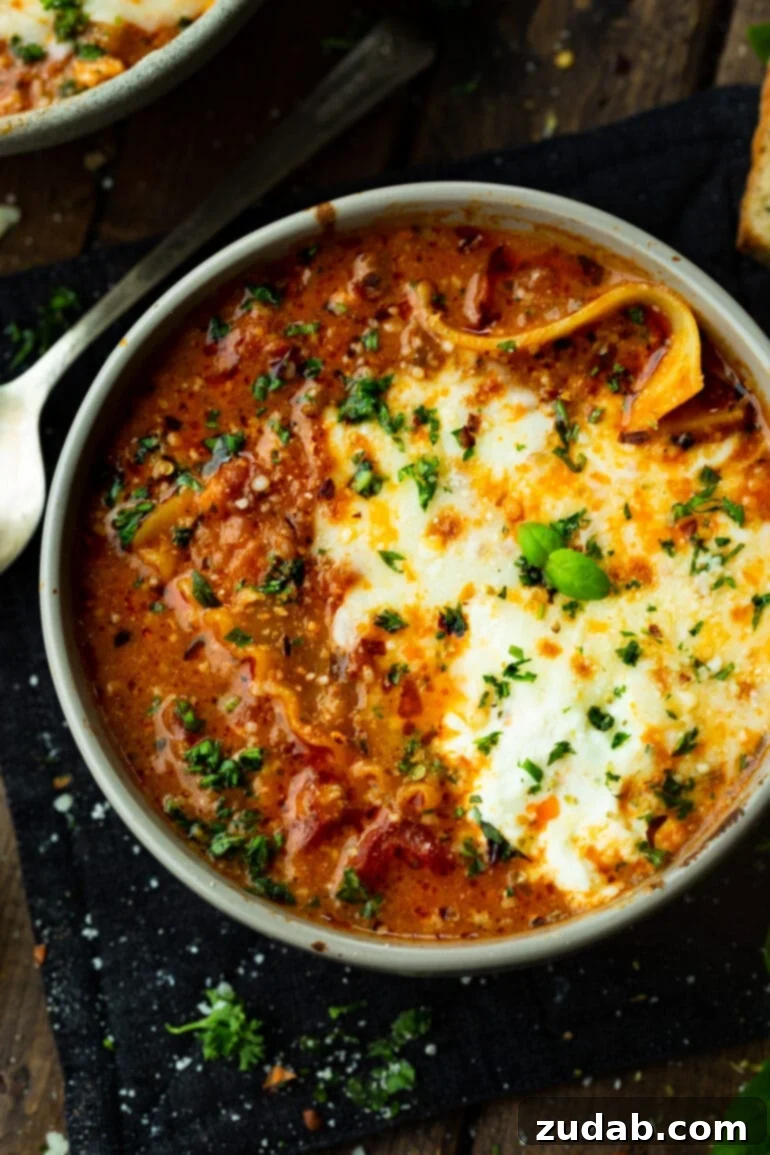 Delicious Lasagna Soup Recipe 4 A rich bowl of hearty lasagna soup, beautifully garnished with melted cheese and a sprinkle of fresh chopped herbs.