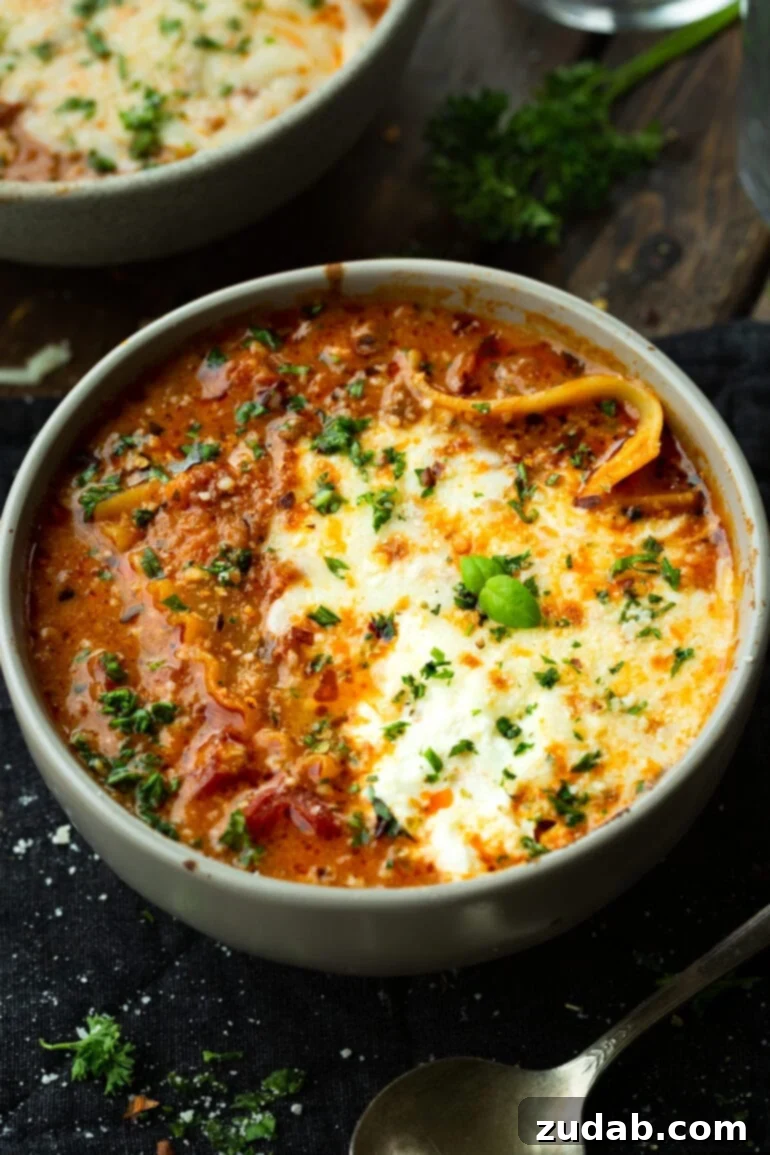 Delicious Lasagna Soup Recipe 10 A large, inviting bowl of lasagna soup, generously adorned with melted mozzarella cheese and a vibrant sprinkle of fresh chopped herbs.