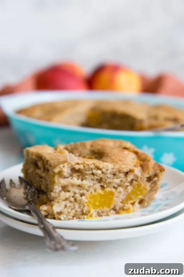 Golden Peach Butter Cake 2 A slice of peach dump cake on a plate, topped with a scoop of vanilla ice cream