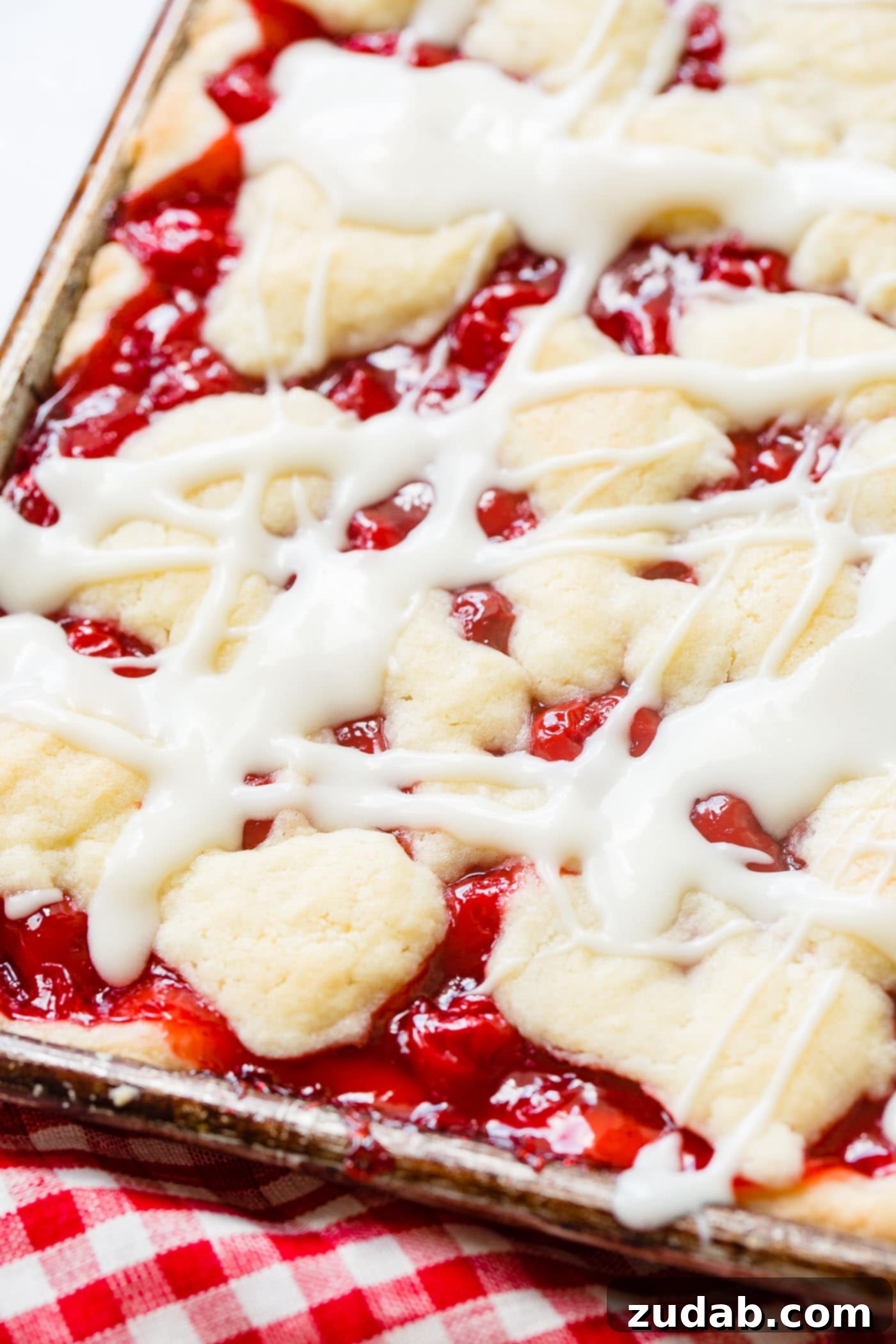 Sweet Cherry Sugar Cookie Bars 7 A sheet pan brimming with baked cherry pie bars, glistening with a delightful glaze.