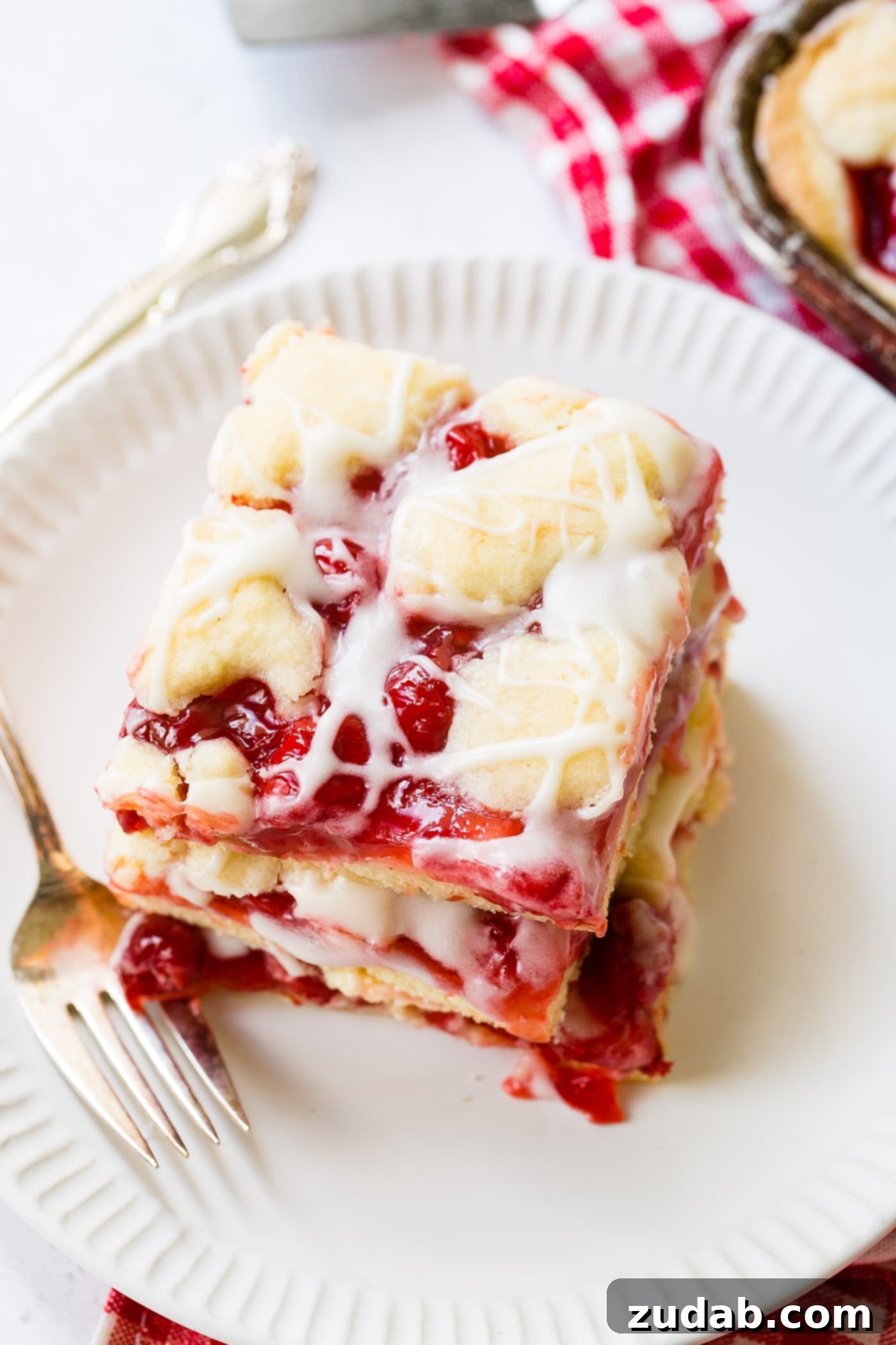 Sweet Cherry Sugar Cookie Bars 8 A stack of three cherry pie bars, impeccably glazed, standing tall and inviting.