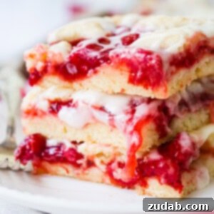 Sweet Cherry Sugar Cookie Bars 9 A close-up of a single sugar cookie sweet cherry pie bar, showing the layers of crust, cherry filling, and glaze.