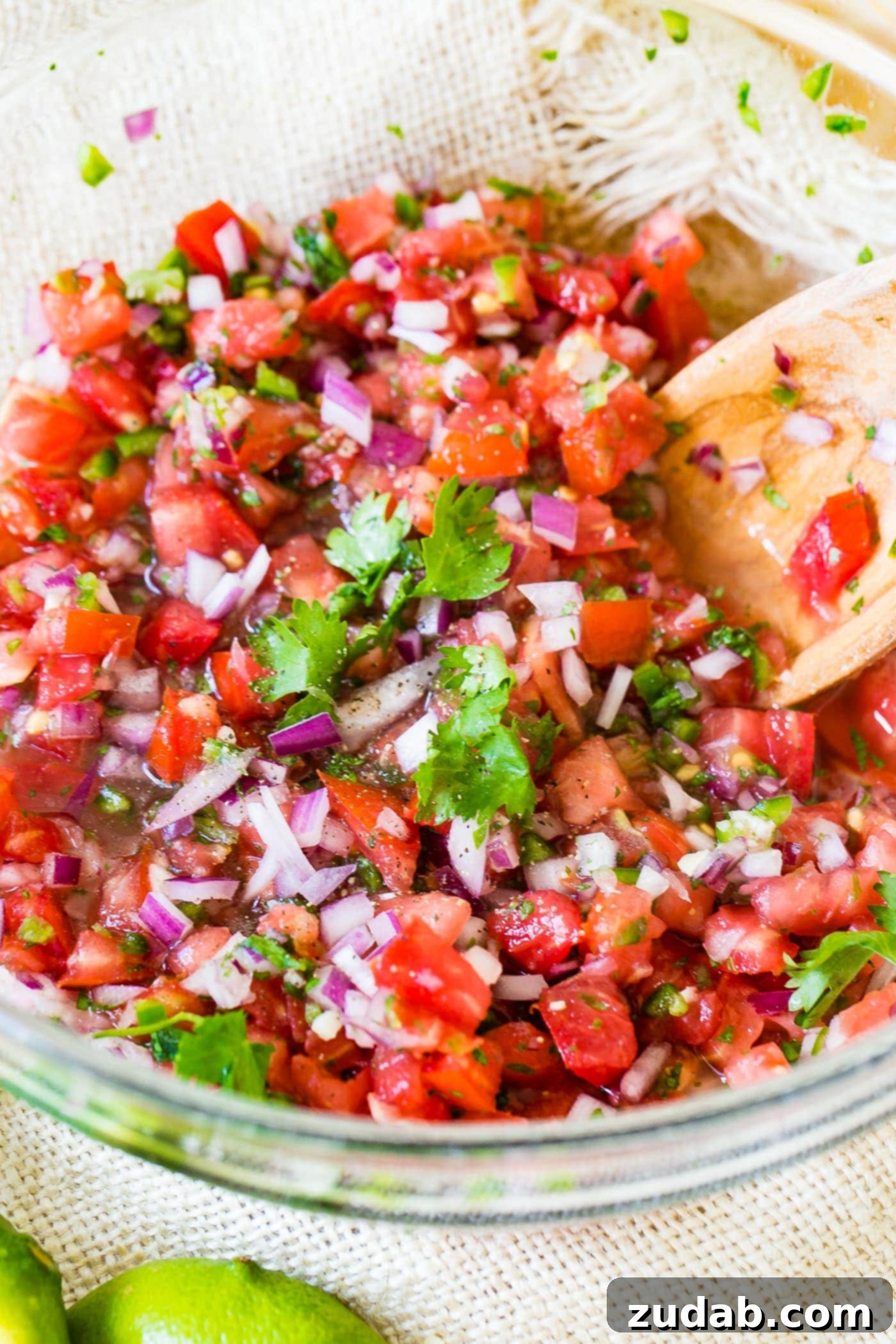 Ready-to-Serve Pico de Gallo A final close-up shot of a glass bowl filled with perfectly mixed homemade Pico de Gallo, inviting a fresh, flavorful bite.