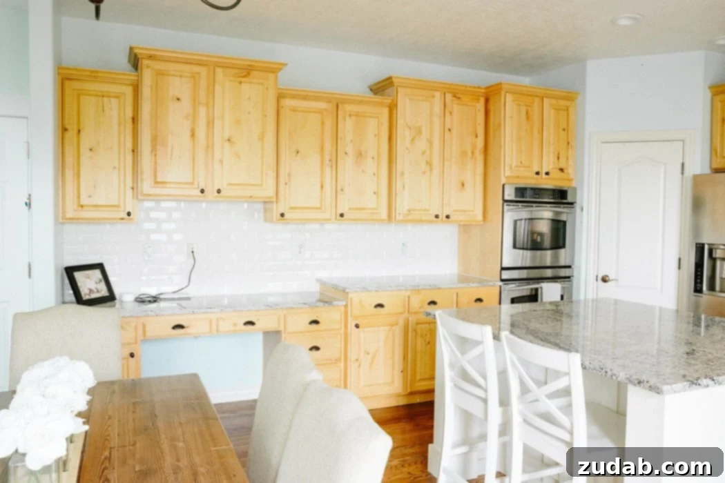 Outdated kitchen before renovation, showing worn cabinets and blue walls